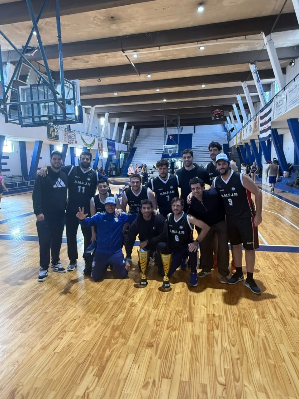 Equipo de básquet de la AMFJN con los trofeos